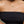 Load image into Gallery viewer, Person wearing a black strapless top and gold necklace with a green gemstone.
