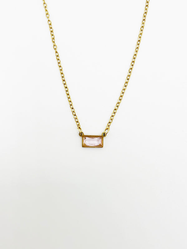 Gold necklace with a rectangular pink gemstone on a white background