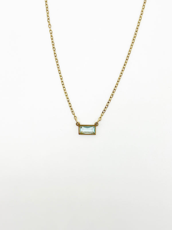 Gold necklace with a rectangular pendant on a white background