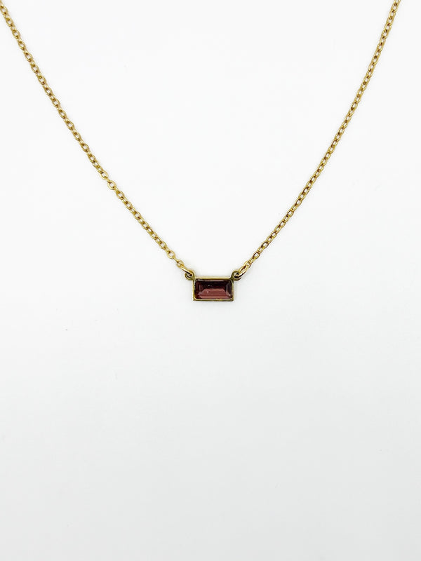 Gold necklace with a rectangular pendant on a white background