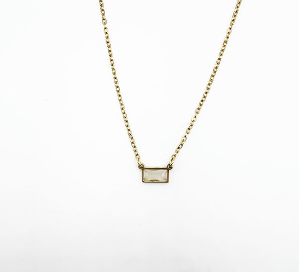 Gold necklace with a rectangular pendant on a white background