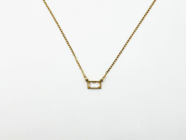 Gold necklace with a rectangular pendant on a white background